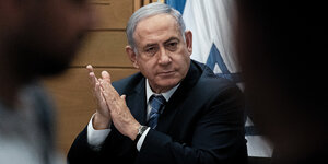 Netanjahu sitzt und hat die Hände gefaltet