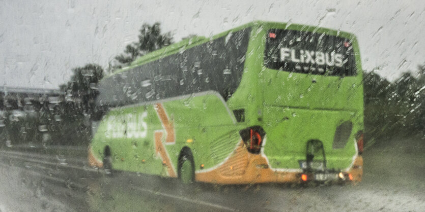 Reisebus im Regen auf einer Straße.