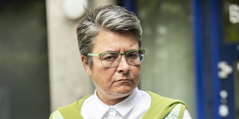 Eine Frau mit Brille, kurzen Haaren und Weste