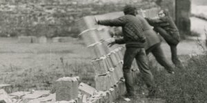 Bei einem Happening in Berlin lassen Männer 1970 eine Mauer einstürzen