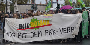 Menschen protestieren mit einem Transparent gegen die Kriminalisierung der PKK