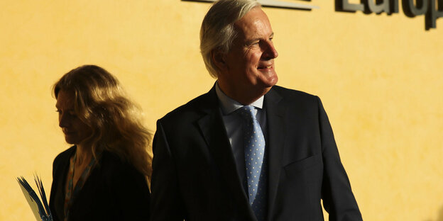 EU-Unterhändler Michel Barnier vor einer gelb leuchtenden Wand des EU-Kommissionsgebäudes