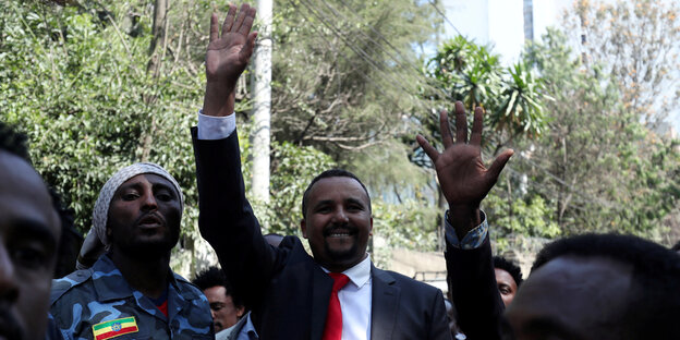 Der äthiopische Internetaktivist Jawar Mohammed steht in einer Menschengruppe und winkt