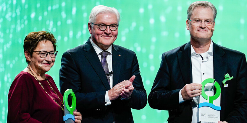 Ingrid Kögel-Knabner hält den Deutschen Umweltpreis. Neben ihr stehen Bundespräsident Frank-Walter Steinmeier und Frosch-Unternehmer Reinhard Schneider, der ebenfall eine Trophäe in Händen hält.