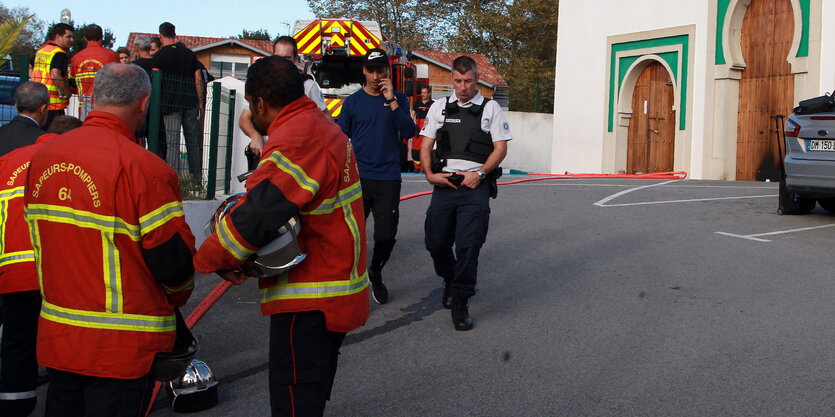 Feuerwehrmänner und Polizisten stehen vor der Moschee in Bayonne