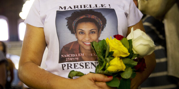 Junge Frau trägt ein T-Shirt mit dem Portrait von Marielle Franco