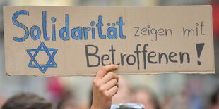 Ein Schild mit der Aufschrift "Solidarität zeigen mit Betroffenen!"