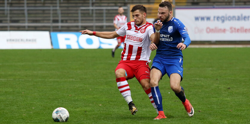 Zweikampf um den Ball im leeren Stadion