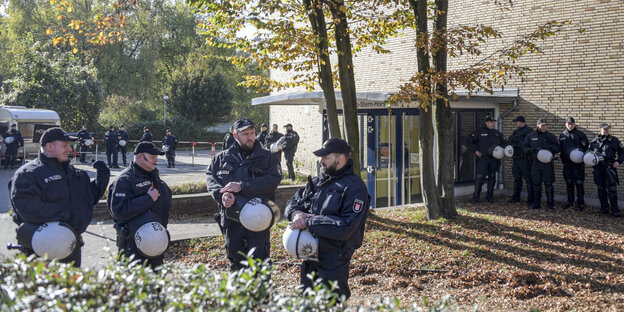 Polizisten warten vor einem Gebäude der Uni Hamburg