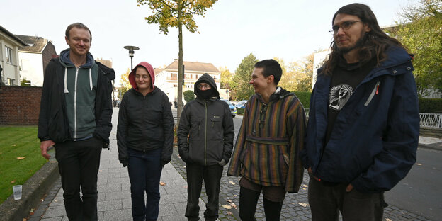 Die fünf Angeklagten stehen vor Beginn ihres Prozesses wegen der Blockade des Braunkohlekraftwerks Weisweiler im November 2017 vor dem Gericht auf der Straße