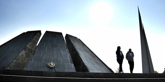 Das Denkmal Tzitzernakaberd bei Jerewan, davor stehen zwei Personen