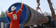Arbeiter befestigt einen Deckel an einem Teilstück der Pipeline
