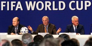 Blatter, Beckenbauer und Radmann sitzen nebeneinander, über ihnen der Schriftzug Fifa World Cup