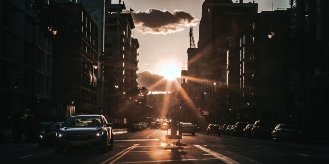 Eine Straße mit Autos, hinter der die Sonne golden untergeht