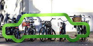 der grüne Umriss eines Autos steht vor Fahrrädern