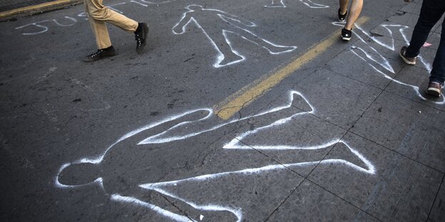 Umrisse von Mensche sind auf eine Straße in Santiago in Chile gesprüht um an die getötetet Demonstranten zu erinnern.