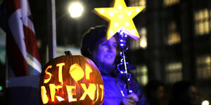 beleuchteter Kurbis mit der Botschaft"Stop Brexit" im Hintergrund eine Frau mit eiem leuchtenden Stern in der Hand