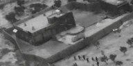 Ein verpixeltes schwarz-weißes Luftbild zeigt Soldaten beim Sturm auf ein Gebäude