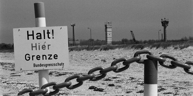 Ein Schild mit der Aufschrift "Halt! Hier Grenze" steht am Strand
