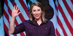 Katie Hill winkend vor US-Flagge