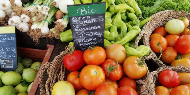 verschiedene Gemüse, darunter Tomaten, an einem Marktstand