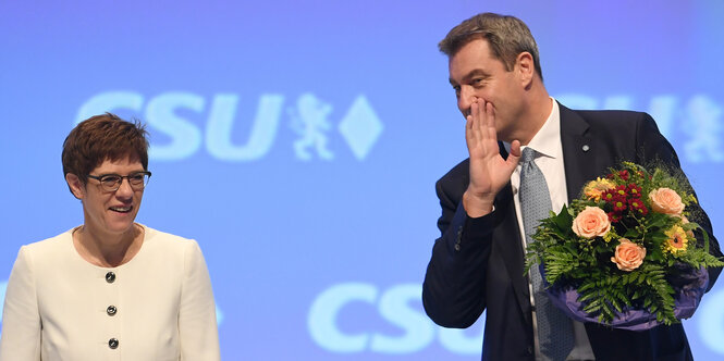 eine Frau steht neben einem Mann, im Hintergrund steht mehrfach groß „CSU“