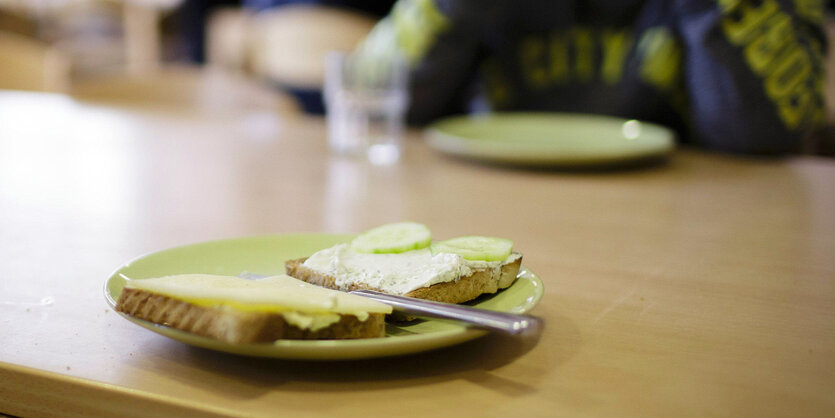 Teller mit Käsebrot und Gurke