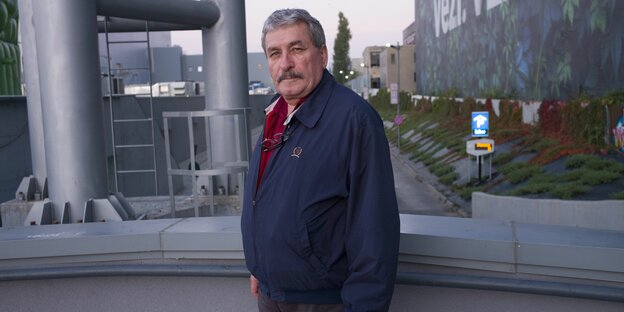 ein älterer Mann vor einem futuristischen Gebäude ein älterer Mann vor einem futuristischen Gebäude