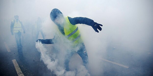 Demonstrant mit gelber Weste in Tränengasschwaden