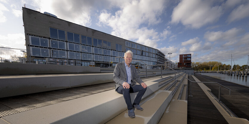 Der Investor Sven Hollesen sitzt vor einem Rohbau.