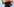 Polizist von hinten fotografiert vor einer wehenden Regenbogenfahne.
