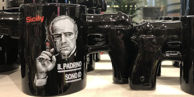 Schwarze Kaffeetassen mit dem Bild von Marlon Brando als Filmfigur "Der Pate"