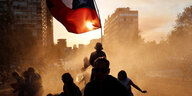 Menschen protestieren mit der chilenischen Fahne gegen die Regierung