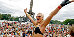 Eine Frau im Bikini vor einer großen Menge Menschen am Platz "Großer Stern" im Berliner Tiergarten