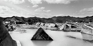 Trümmer liegen im Wasser, schwarz-weiß Foto