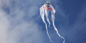 Ein Drachen der Aktivistengruppe Extinction Rebellion in fliegt in der Luft