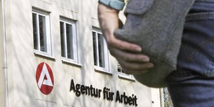 ein Mensch steht vor der Agentur für Arbeit in Weißenfels