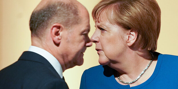 Olaf Scholz und Angela Merkel stehen sich gegenüber