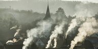 Rauch steigt aus Schornsteinen von Wohnhäuseren in Oberstenfeld in Baden-Würtemberg