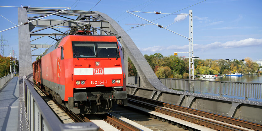 Eine Elektrolokomotive 152 zieht einen Güterzug über eine Brücke