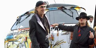 Udo Lindenberg und sein Bassist stehen vor einem bunt angemalten Zug