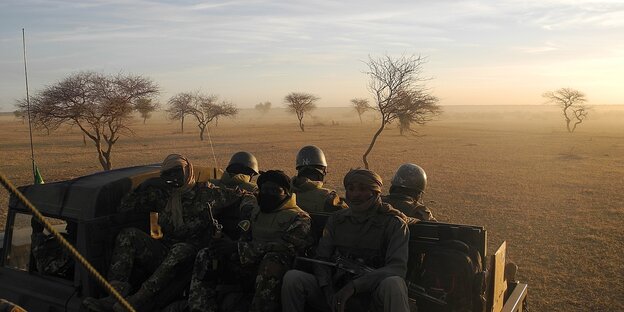 Soldaten aus Mali sitzen auf einem Militärfahrzeugnahe der Grenze zu Burkina Faso