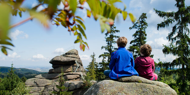 Zwei Schüler sitzen auf einem Felsen im Harz