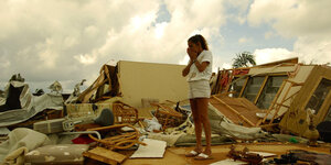 Eine Frau steht auf den Trümmern ihres vom Hurrikan zerstörten Hauses