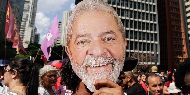 Ein Demonstrant trägt eine Maske mit dem Konterfei von Lula da Silva
