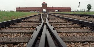 Das Tor des Konzentrationslagers Auschwitz-Birkenau mit den Gleisen, die auf das Tor hinführen