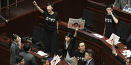 Pro-demokratische Abgeordnete protestieren, während Regierungschefin Lam eine Rede vor dem Legislativrat hält.