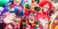 Menschen haben sich für einen Karnevalsumzug als Clowns verkleidet.