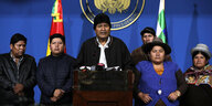 Evo Morales steht am Mikrofon begleitet von Anhängern