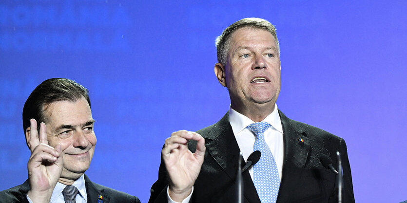 Premierminister Ludovic Orban mit Victory Zeichen und Klaus Iohannis vor dem Mikrofon